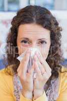 Sick woman blowing her nose