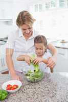 Mother and daughter preparing salad