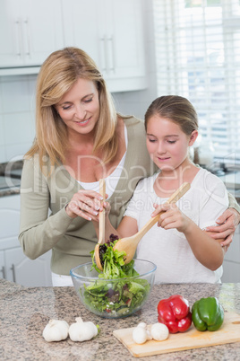 Mother and daughter preparing salad together