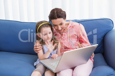 Mother and daughter video chatting with laptop