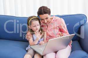 Mother and daughter video chatting with laptop