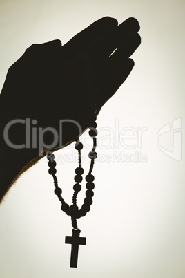 Hand holding rosary beads