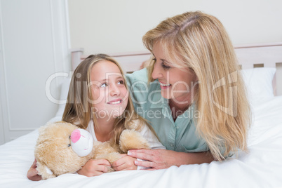 Happy mother and daughter smiling at each other