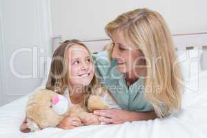 Happy mother and daughter smiling at each other