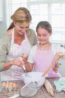 Mother and daughter making cake together