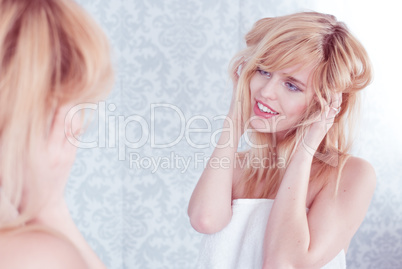 Young Smiling Woman Tousling Hair in Mirror