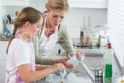 Mother and daughter washing up together