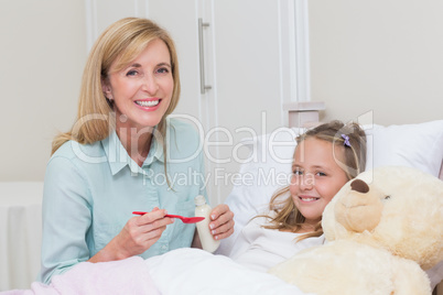 Mother giving her daughter cough medicine