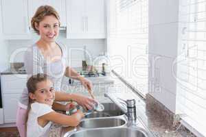 Mother and daughter washing up