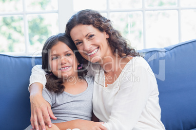 Happy mother and daughter smiling at camera