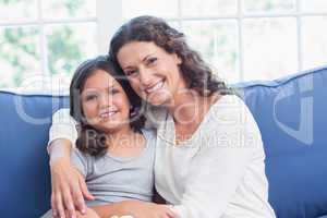 Happy mother and daughter smiling at camera