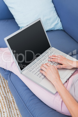 Casual woman using laptop on couch