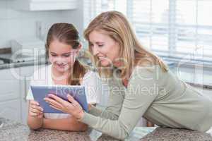 Happy mother and daughter using tablet pc together