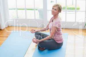 Mature woman doing yoga on fitness mat