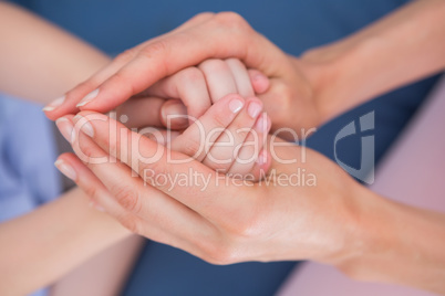 Mother and daughter touching hands