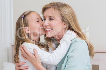 Cute little girl kissing her mother