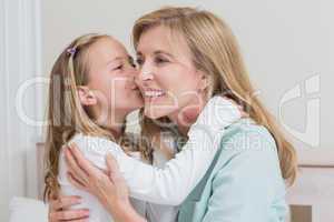 Cute little girl kissing her mother