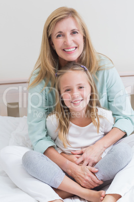 Happy mother and daughter smiling at camera