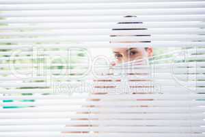 Woman peeking through blinds