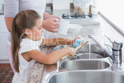 Mother and daughter washing up