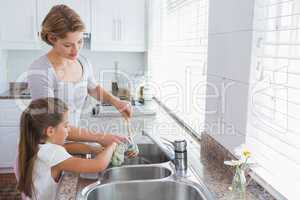 Mother and daughter washing up