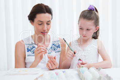 Mother and daughter painting easter eggs