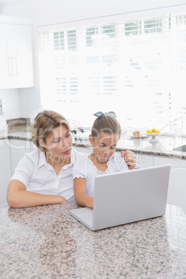 Mother and daughter using laptop