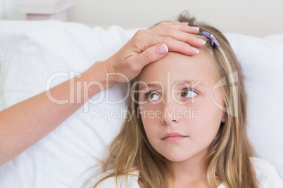 Mother measuring her daughters temperature