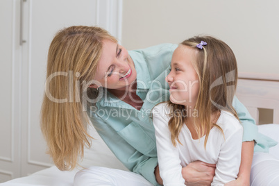 Happy mother and daughter smiling at each other