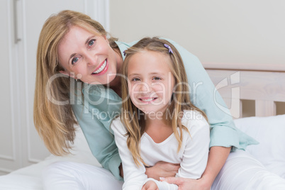 Happy mother and daughter smiling at camera