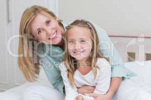 Happy mother and daughter smiling at camera