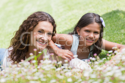 Happy mother and daughter lying on the grass