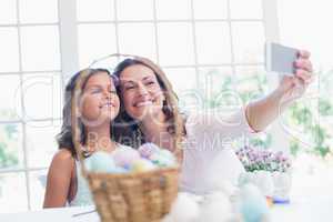 Happy mother and daughter taking selfie