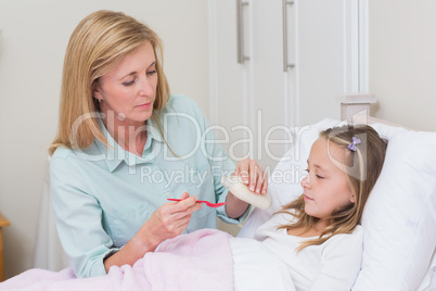 Mother giving her daughter cough medicine