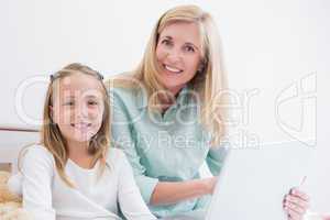 Happy mother and daughter using laptop