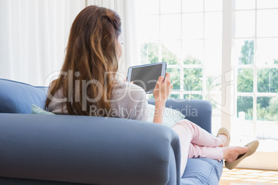 Casual woman using tablet on couch