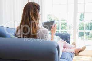 Casual woman using tablet on couch