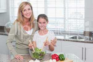 Mother and daughter preparing salad together