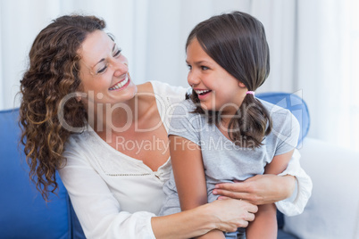 Happy mother and daughter smiling at each other