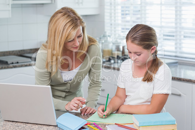 Mother helping daughter doing homework