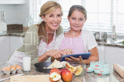 Happy mother and daughter preparing cake together