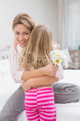 Mother and daughter hugging with flowers