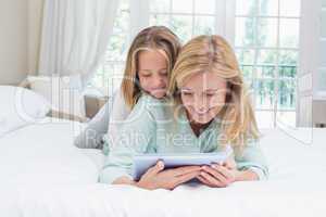 Happy mother and daughter using tablet