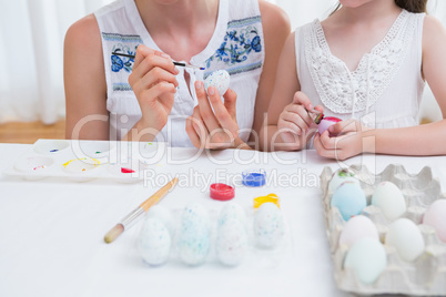 Mother and daughter painting easter eggs