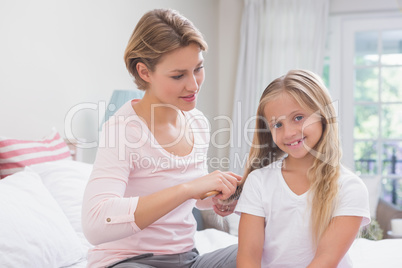 Mother brushing her daughters hair