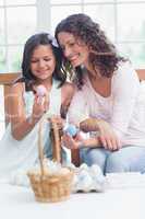 Happy mother and daughter holding easter eggs