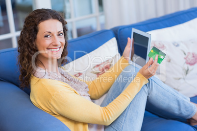 Pretty brunette relaxing on the couch with tablet