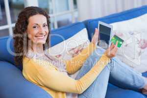 Pretty brunette relaxing on the couch with tablet