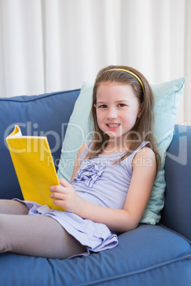 Little girl reading on couch