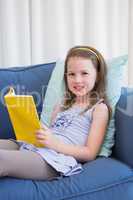 Little girl reading on couch